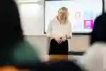 A lecturer smiling while hosting a seminar in the Business School
