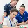 A group of health students stand around a desk