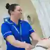 A student midwife stands next to a pregnant patient