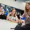 Secondary students sat around a table in a marketing workshop