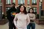 Three students stand confidently outside the Brynmor Jones Library