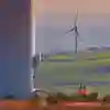 Two people pictured at the base of a wind turbine