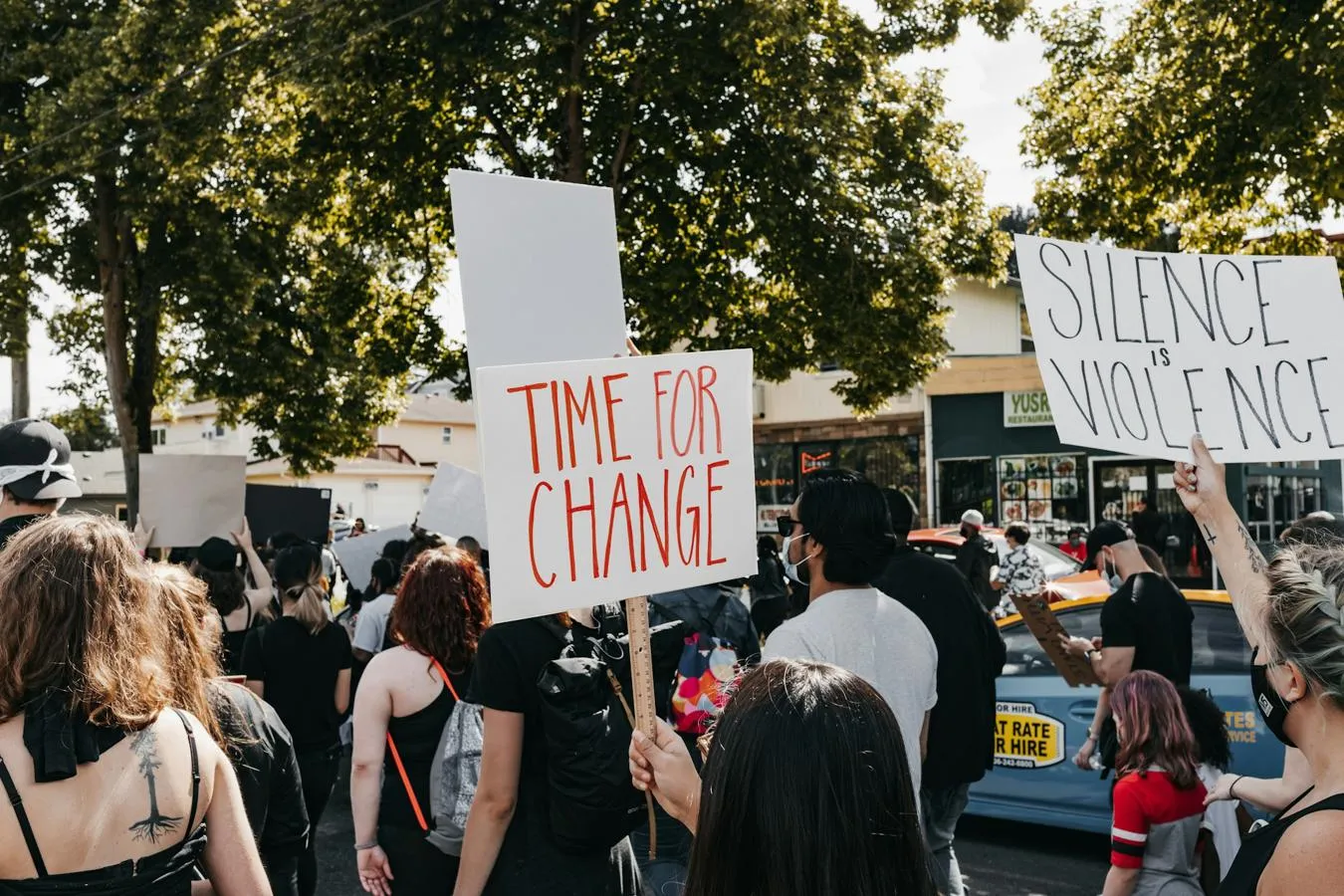 Protestors with signs saying time for change and silence is violence