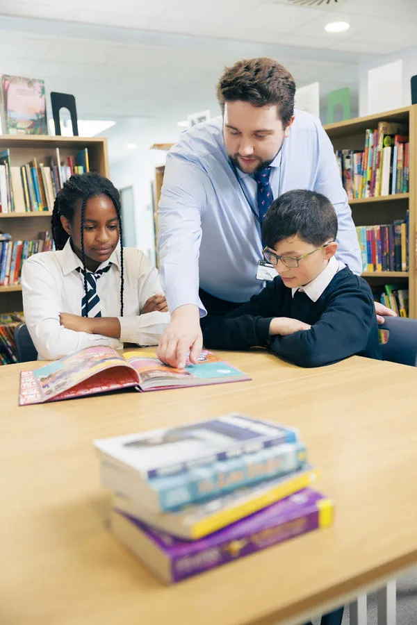 Teacher teaching students at a desk