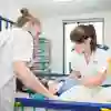 Two children's nursing students practise in the university's neonatal room