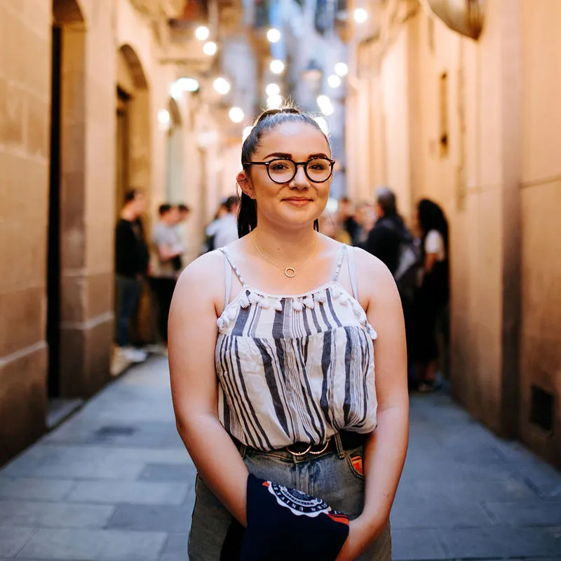Student stands in middle of beige Barcelonan street