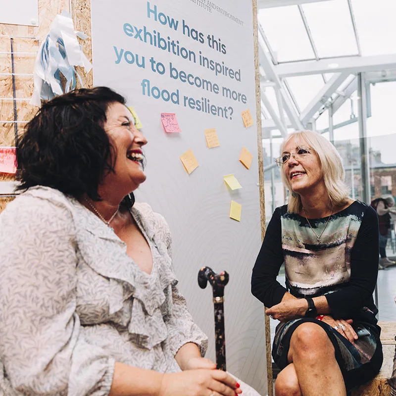 Community members and Risky Cities project team members chat at the textiles exhibition