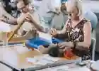 Two people practice weaving in a Risky Cities textiles workshop