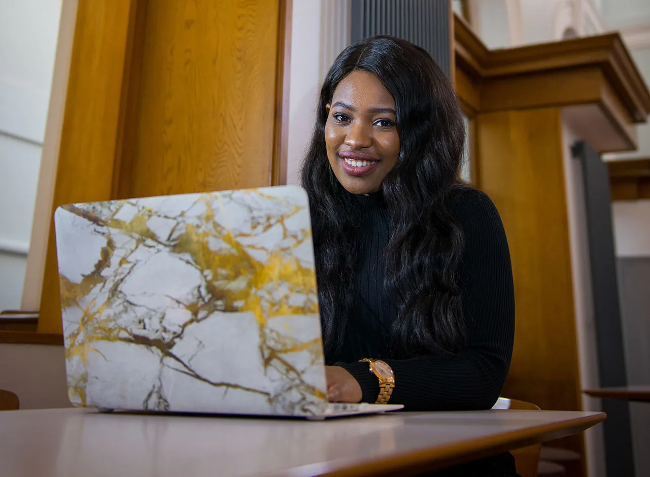 Student sitting at a desk with an open laptop