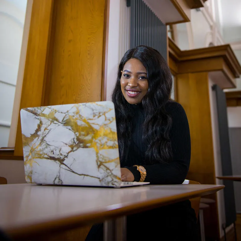 Student sitting at a desk with an open laptop