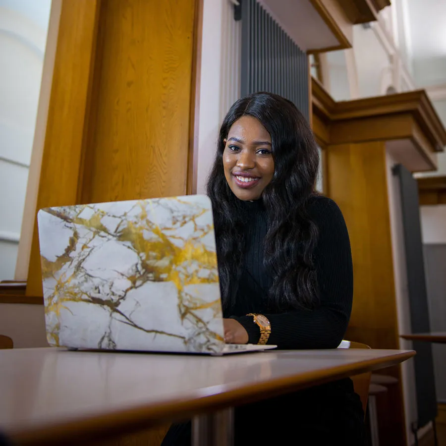 Student sitting at a desk with an open laptop