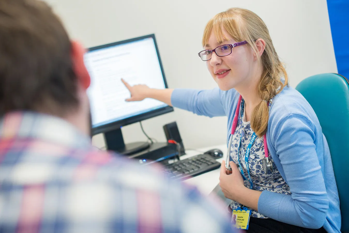 Woman showing a man something on a computer screen