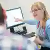 Woman showing a man something on a computer screen