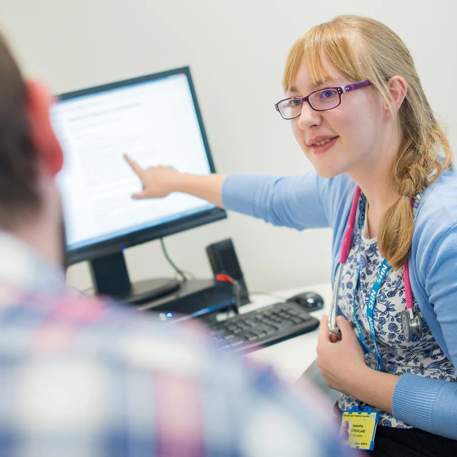 Woman showing a man something on a computer screen