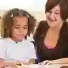 Schoolchildren and their teacher reading in classroom