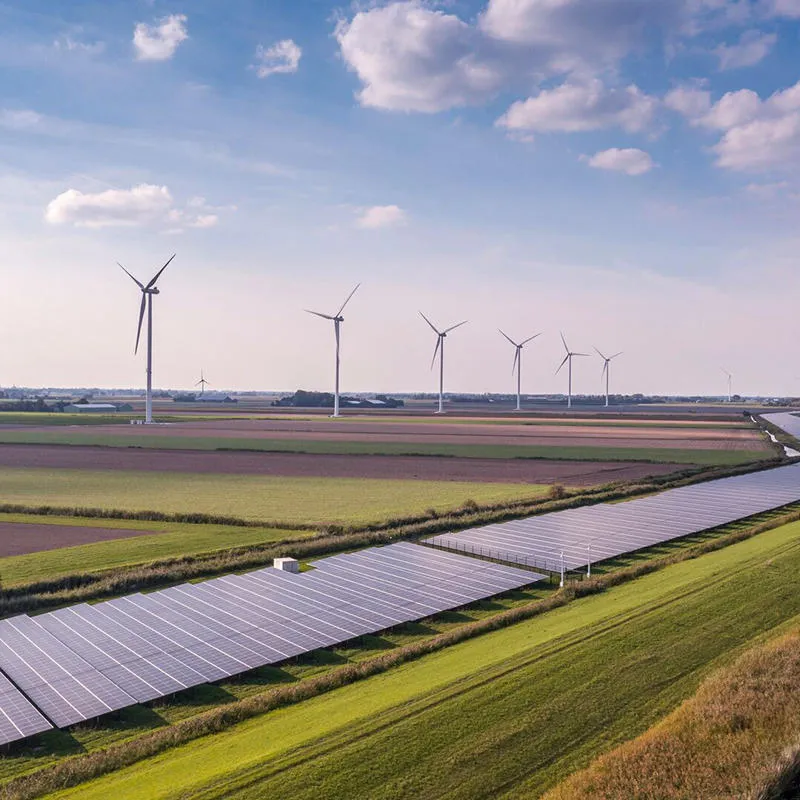 Solar panels and wind turbines in a green field