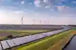Solar panels and wind turbines in a green field