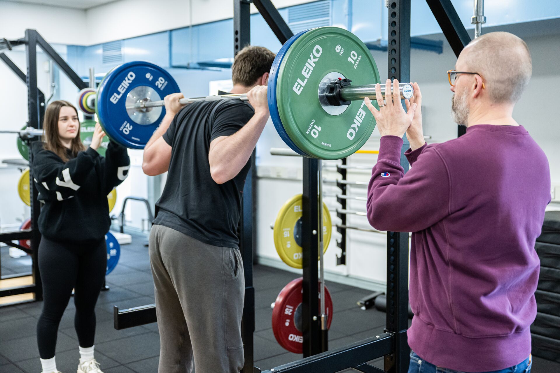 Man performing a barbell squat in the Strength and Conditioning Suite at the University of Hull.