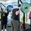 Man performing a barbell squat in the Strength and Conditioning Suite at the University of Hull.