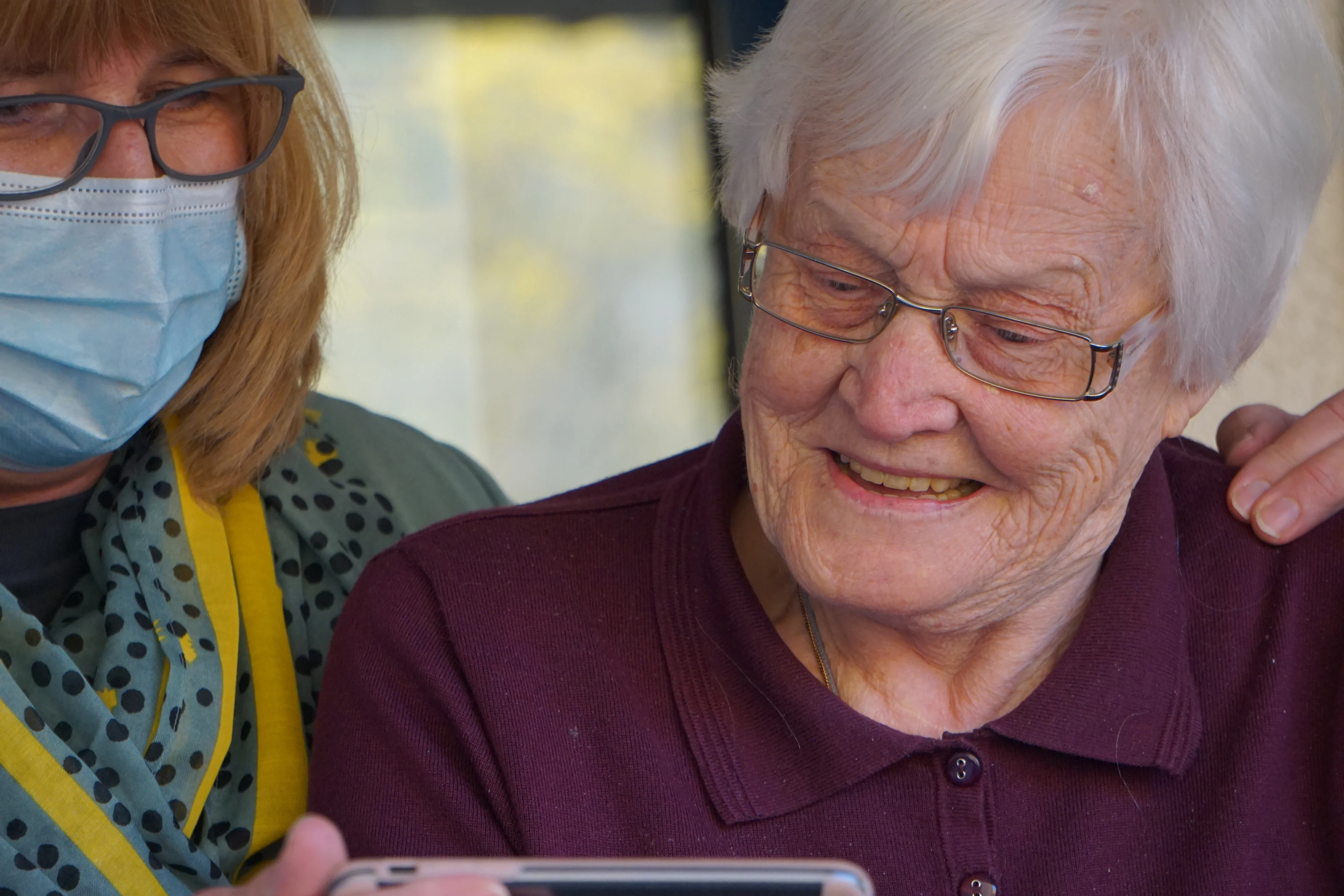 An elderly patient and a careworker review results on an iPad