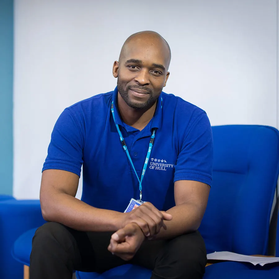 Man wearing a University of Hull t-shirt smiles directly at camera