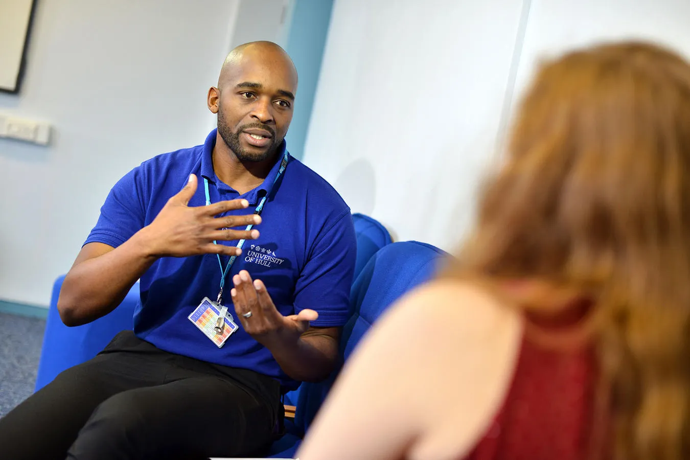 A male nursing student sat down talking to a patient