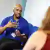 A male nursing student sat down talking to a patient