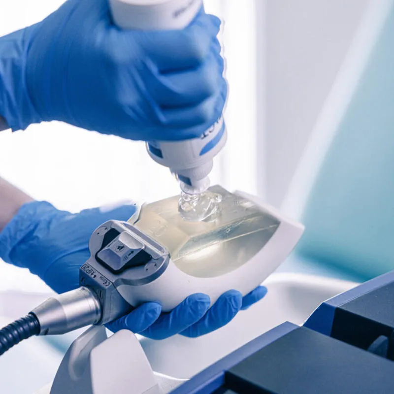 A clinician in blue gloves sets up a shockwave device