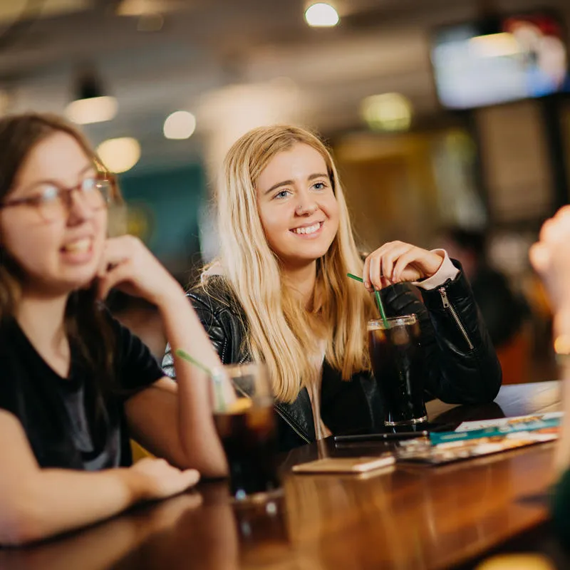 Students chatting over drinks in the bar