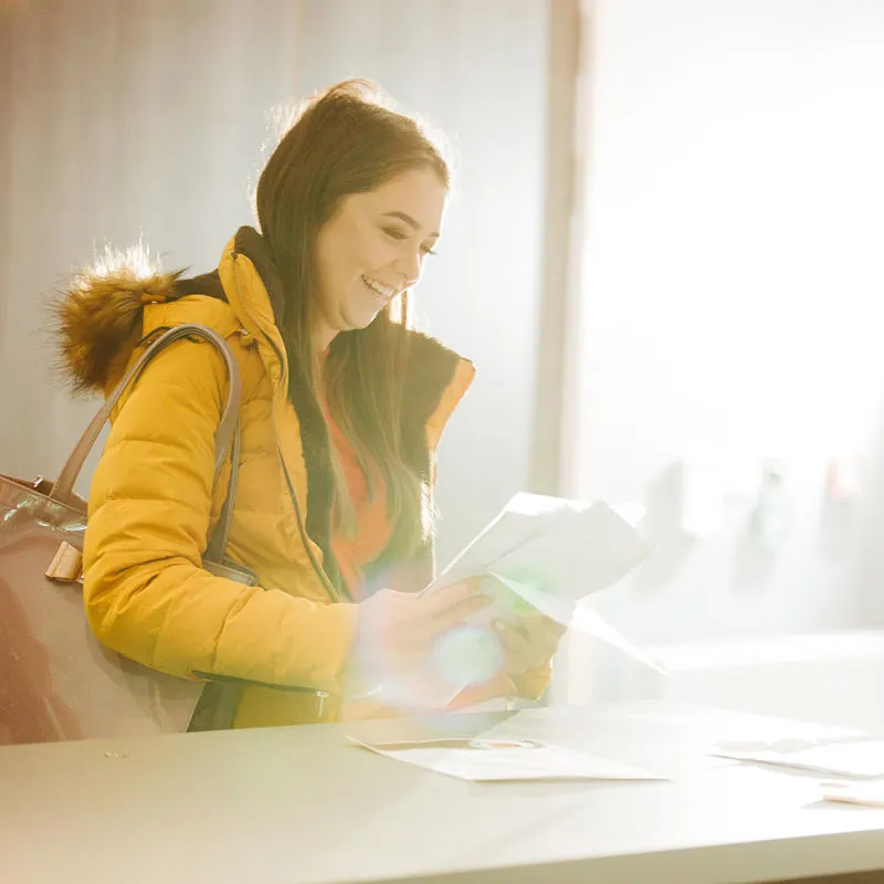 student picking up folder at check in desk