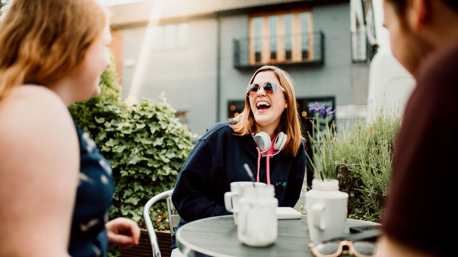 Students sat outside on retail park drinking coffee together