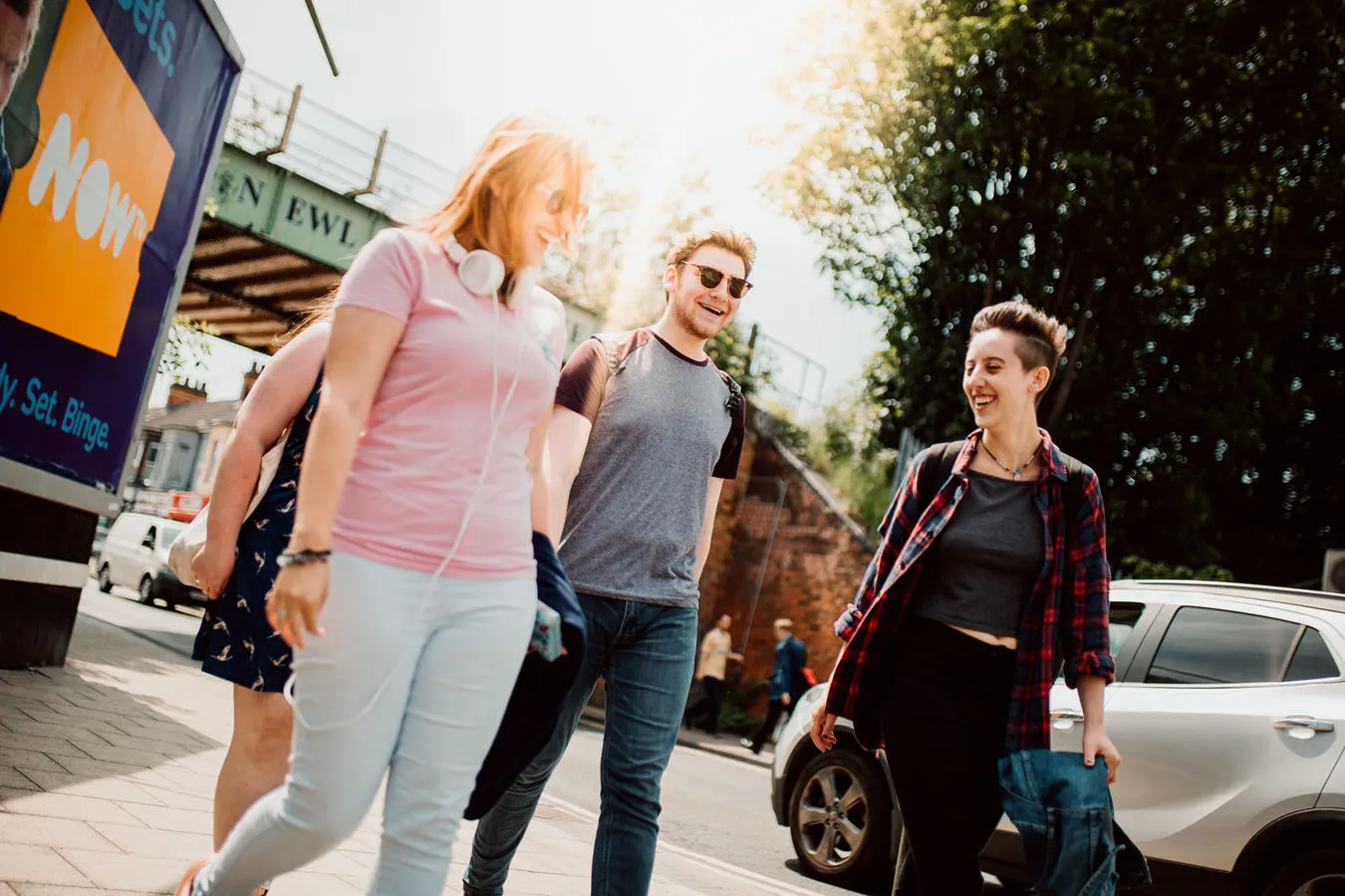 3 students walking down a street in the sunshine