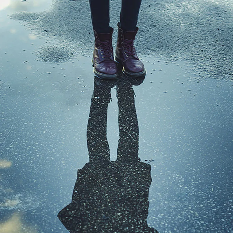 Reflection of a figure in a puddle