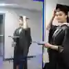 Student wearing graduation robes looking at the mirror