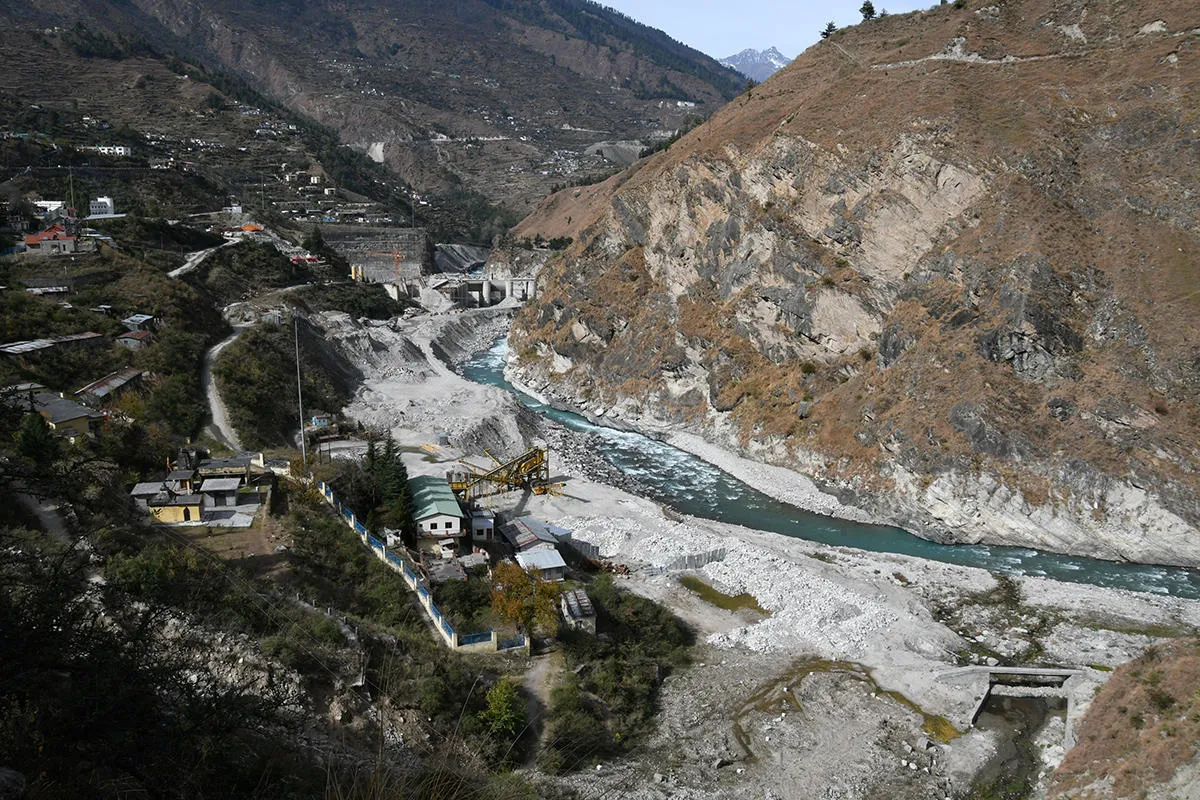 A river winds through a valley with historic destruction visible on either bank 