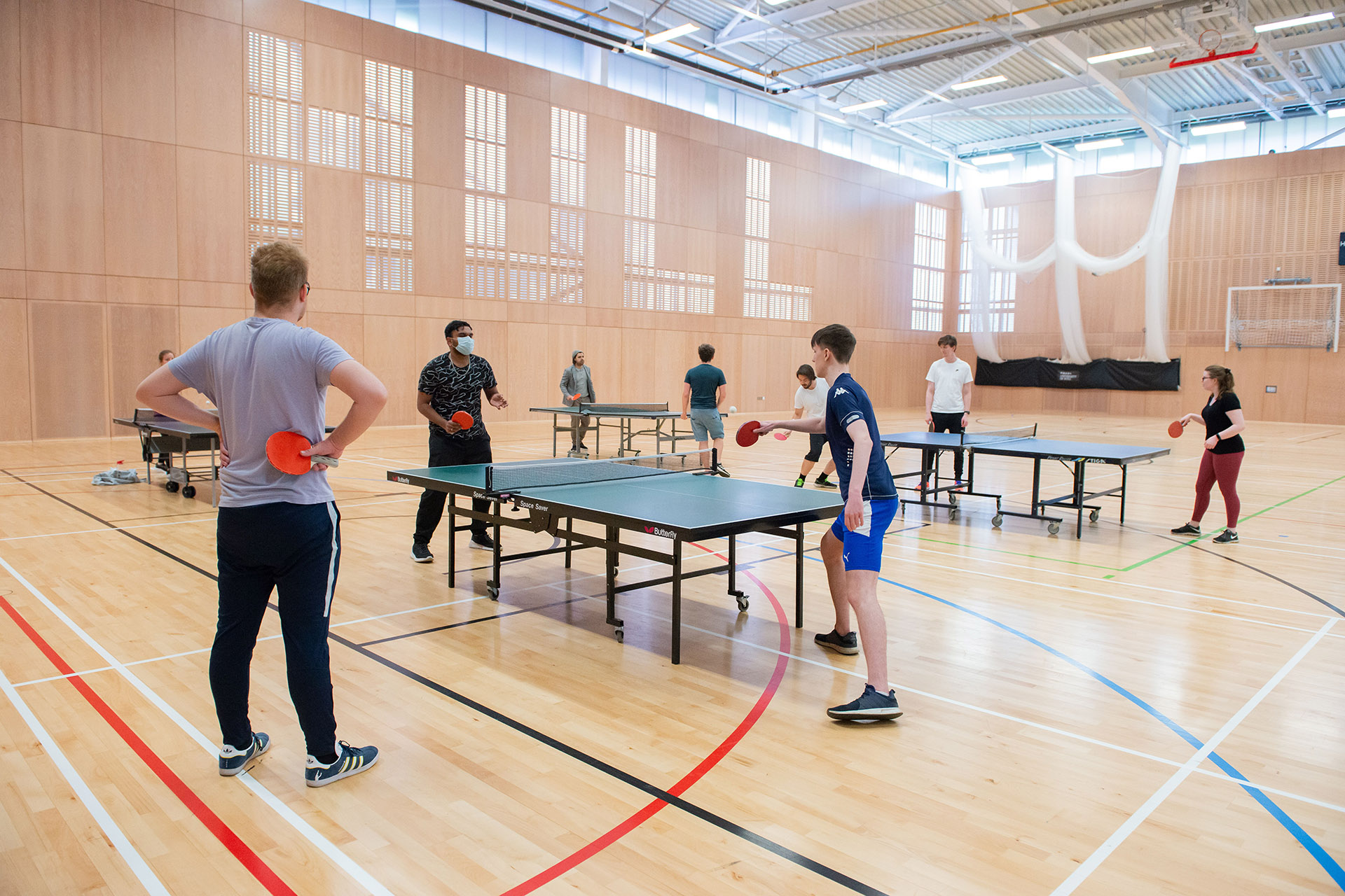 students playing table tennis inside sports hall
