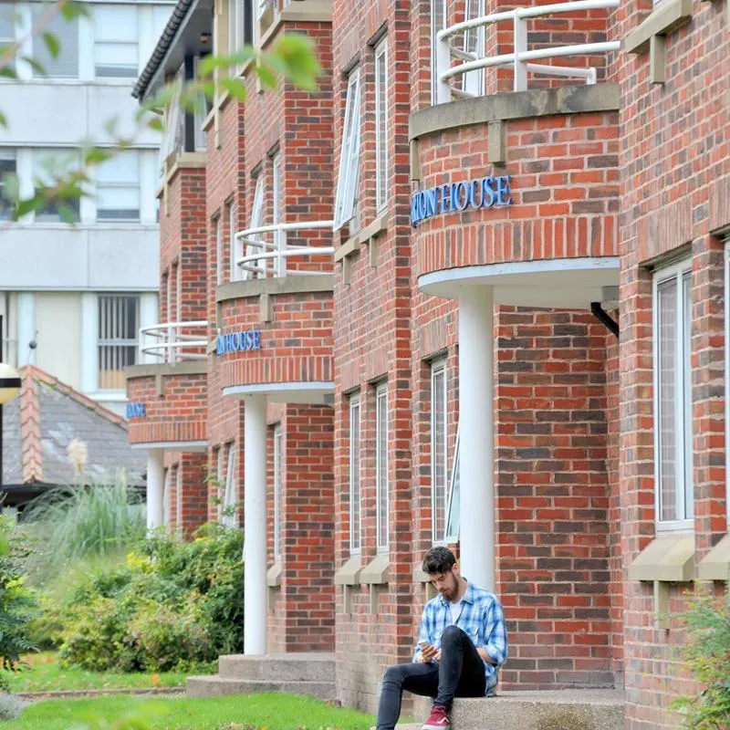 A student sat outside Taylor Court