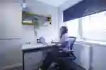 A Student in their Room at the desk in Taylor Court