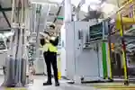 A mechanical engineering student intern in hi-vis is pictured at Howdens Joinery