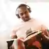 Student with headphones sits and reads a book