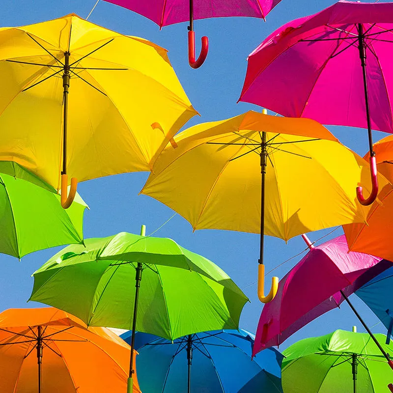 Colourful umbrellas against a blue sky