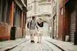 two students walking down a historic cobbled street