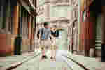 two students walking down a historic cobbled street