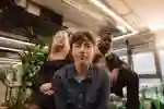 Three students sat in a study space looking at camera
