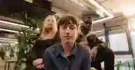 Three students sat in a study space looking at camera