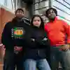 Three International Students stood on the steps outside the Student Union