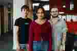 Three students standing confidently in the Allam Medical Building