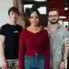 Three students standing confidently in the Allam Medical Building