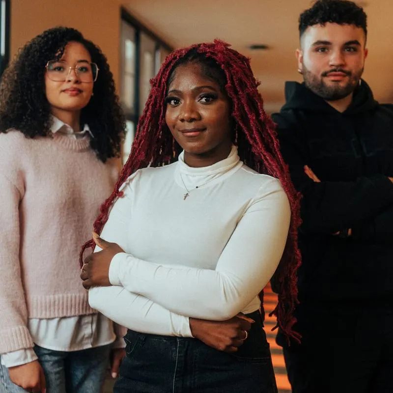 trio of students posing in corridor