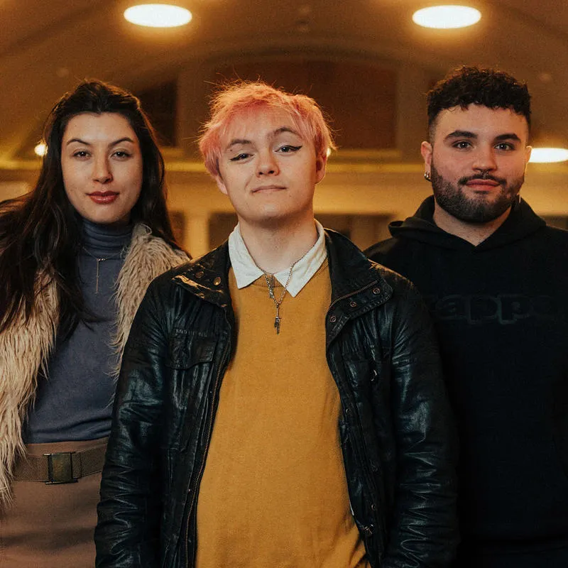 three students standing a line looking at the camera
